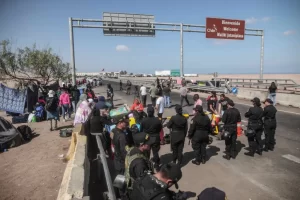 Migrantes esperan en el paso fronterizo de control entre Santa Rosa (Perú) y Chacalluta (Chile), el jueves 27 de abril de 2023. EFE/Aldair Mejía