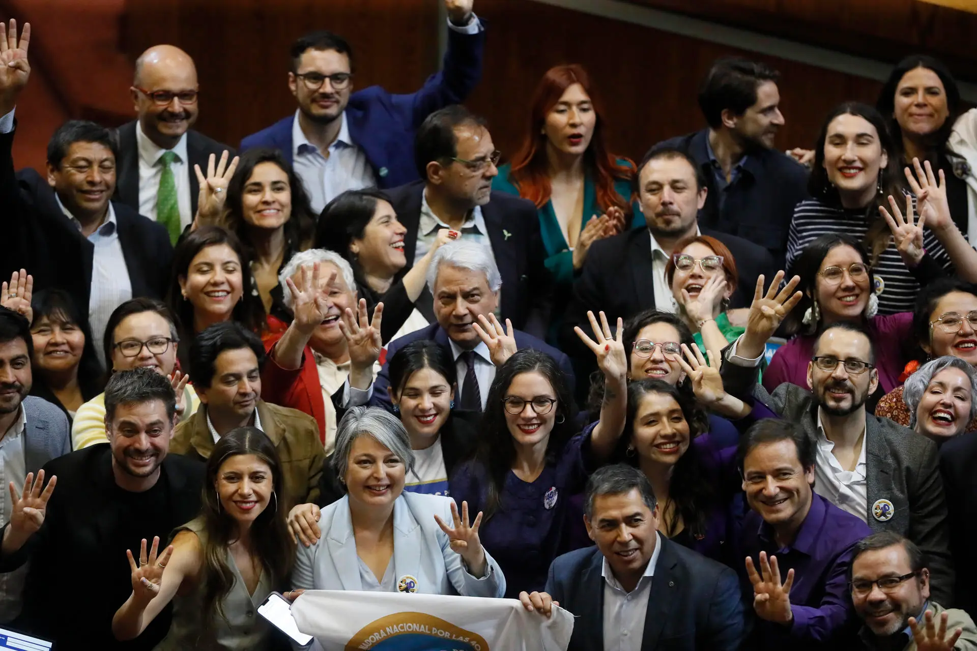 Fotografía cedida por la Cámara de Diputados de Chile, de los ministros de trabajo, Jeannette Jara (3i-abajo ); Secretaria General de Gobierno, Camila Vallejo (c-abajo), mientras celebran junto a distintos diputados, después de la votación del proyecto de 40 horas laborales, en el Congreso Nacional, Valparaíso (Chile). EFE/ Cámara de Diputados de Chile