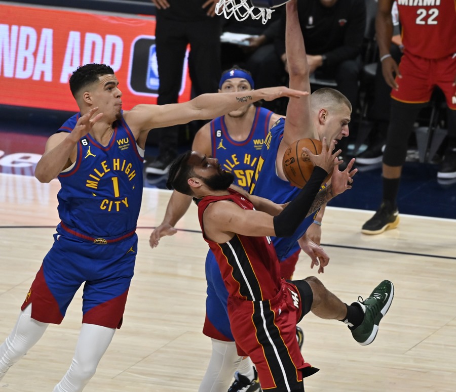 El jugador de los Miami Heat Caleb Martin (c) disputa un balón con Michael Porter Jr. (i), de los Denver Nuggets. EFE/EPA/Bob Pearson
