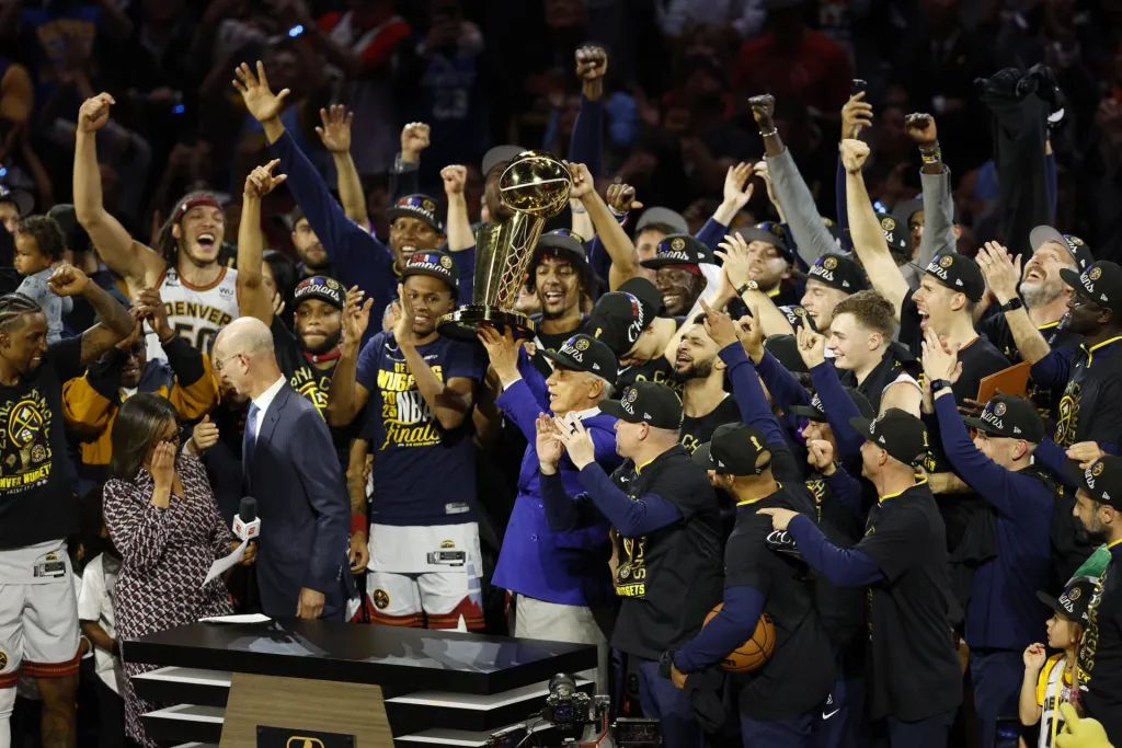 El propietario de los Denver Nuggets, Stan Kroenke (c), sostiene el trofeo del Campeonato de la NBA junto a los jugadores luego de su victoria en el quinto juego de las Finales de la NBA sobre el Miami Heat. EFE/John G. Mabanglo