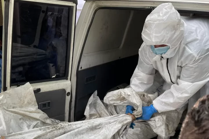 Empleados de medicina forense trasladan un cuerpo de una privada de libertad para realizar la autopsia médico legal, tras la reyerta seguida de un incendio en el Centro Femenino de Adaptación Social (Cefas), en Tegucigalpa (Honduras). EFE/Germán Reyes