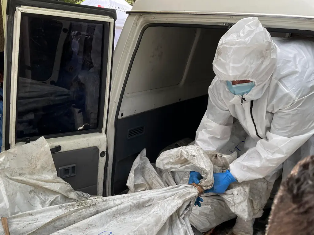 Empleados de medicina forense trasladan un cuerpo de una privada de libertad para realizar la autopsia médico legal, tras la reyerta seguida de un incendio en el Centro Femenino de Adaptación Social (Cefas), en Tegucigalpa (Honduras). EFE/Germán Reyes