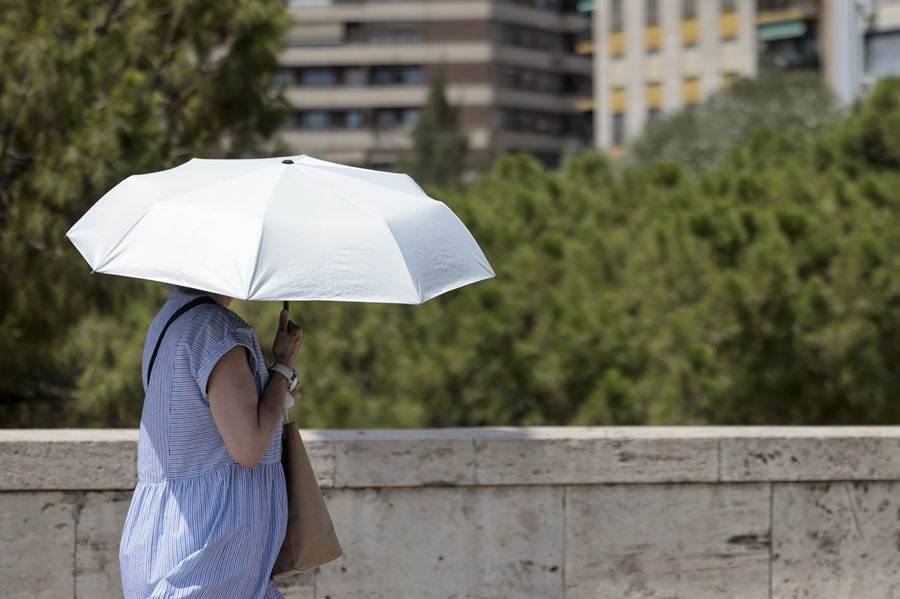 Una persona se protege de las altas temperaturas con un parasol. EFE/Ana Escobar/Archivo