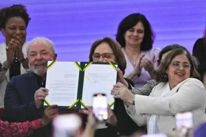 El presidente de Brasil, Luiz Inácio Lula da Silva, posa hoy junto a la ministra de las Mujeres, Cida Gonçalves (d), y otras altas funcionarias, tras firmar la ley que establece igualdad salarial entre mujeres y hombres, en la Base Aérea Militar de Brasilia (Brasil). EFE/André Borges