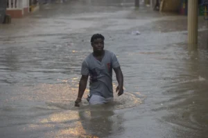 Personas caminan hoy por calles inundadas debido al paso de la tormenta tropical Franklin, en Santo Domingo (República Dominicana). EFE/Orlando Barría