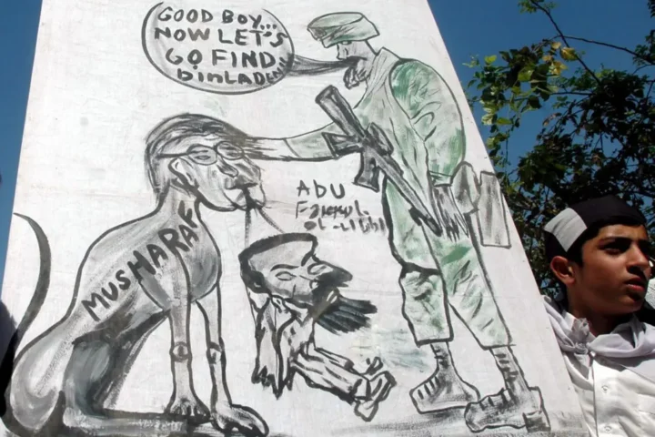 Fotografía de archivo del 13 de mayo de 2005 que muestra a un simpatizante del partido religioso "Shabab-e-Milli", que participa en una manifestación en Islamabad (Pakistán) y muestra una viñeta satírica publicada por el periódico Washington Times que ha levantado una ola de protestas en contra de los Estados Unidos. EFE/T.mughal