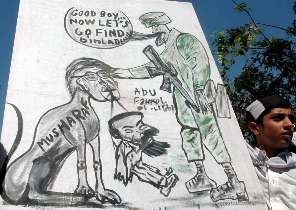 Fotografía de archivo del 13 de mayo de 2005 que muestra a un simpatizante del partido religioso "Shabab-e-Milli", que participa en una manifestación en Islamabad (Pakistán) y muestra una viñeta satírica publicada por el periódico Washington Times que ha levantado una ola de protestas en contra de los Estados Unidos. EFE/T.mughal