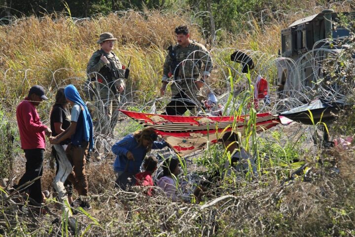Migrantes son retenidos por La Guardia Nacional estadounidense al cruzar el Río Bravo para intentar ingresar a Estados Unidos en Matamoros (México). EFE/Abrahan Pineda-Jacome