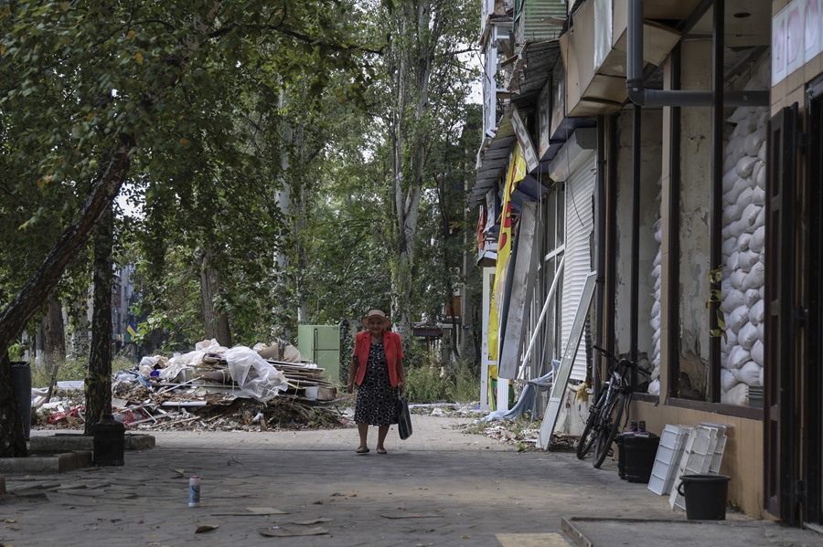 Una mujer camina por una calle bombardeada de Avdiivka, cerca del frente en la región de Donetsk, en el este de Ucrania. EFE/EPA/Alex Babenko
