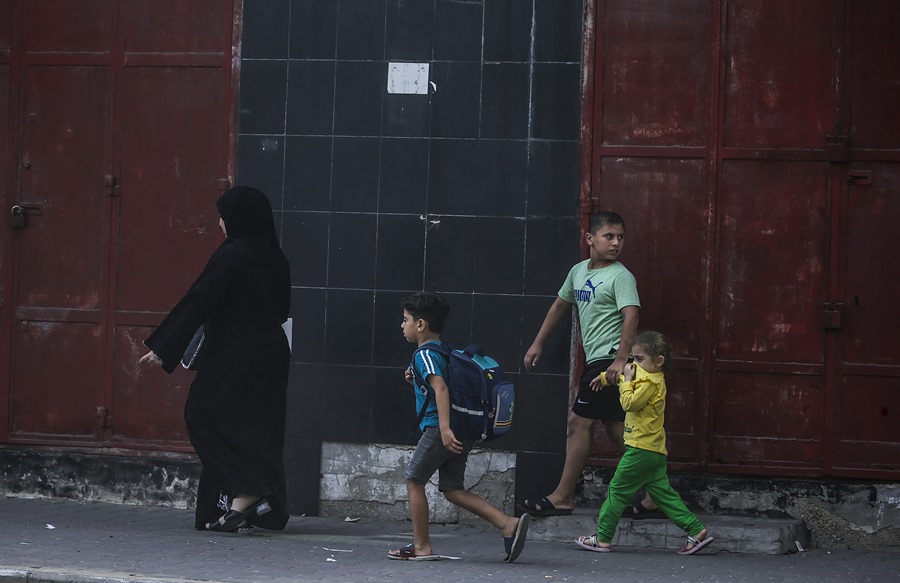 Una madre palestina huye con sus hijos durante un ataque aéreo israelí sobre Gaza. EFE/EPA/Mohammed Sable