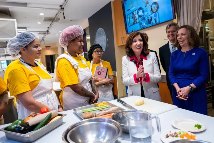 Fotografía cedida por la Gobernación de Nueva York donde aparece su gobernadora Kathy Hochul (c) mientras habla con unas empleadas hoy en Hot Bread Kitchen en el Mercado Chelsea, en Nueva York. EFE/Susan Watts/Gobernación de Nueva York