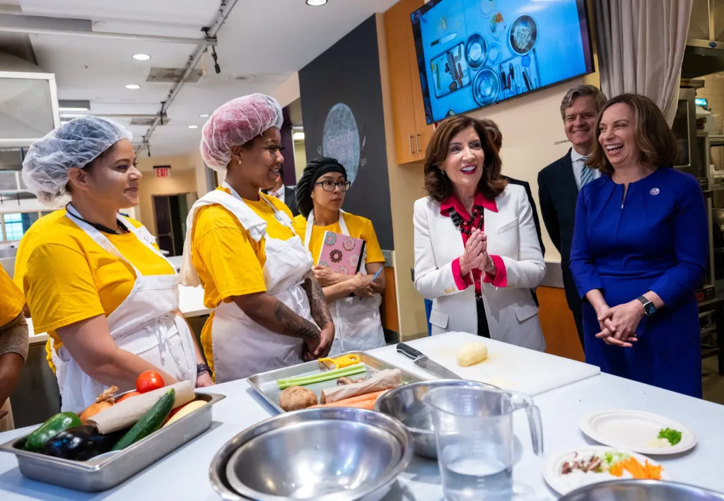 Fotografía cedida por la Gobernación de Nueva York donde aparece su gobernadora Kathy Hochul (c) mientras habla con unas empleadas hoy en Hot Bread Kitchen en el Mercado Chelsea, en Nueva York. EFE/Susan Watts/Gobernación de Nueva York