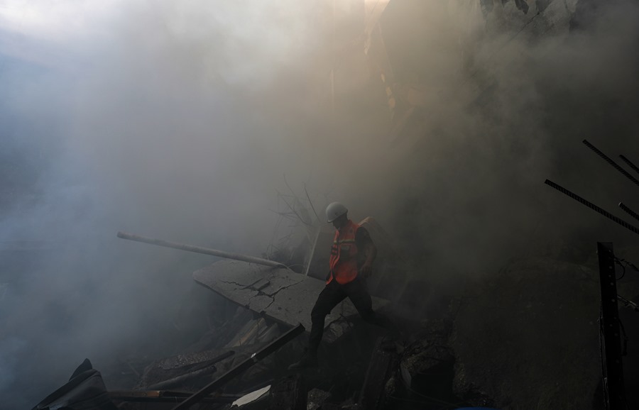Un miembro de los servicios de emergencia en un edificio atacado por el ejército israelí en la ciudad de Gaza, este sábado. EFE/EPA/Mohammed Saber