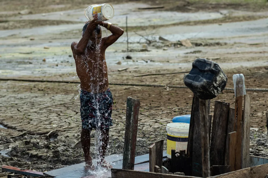 El pescador y comerciante Raimundo Silva do Carmo, de 67 años, se baña con agua de un pozo que él mismo había cavado en una zona seca del Lago do Puraquequara, el 6 de Octubre del 2023, en Manaos, Amazonas (Brasil). EFE/ Raphael Alves