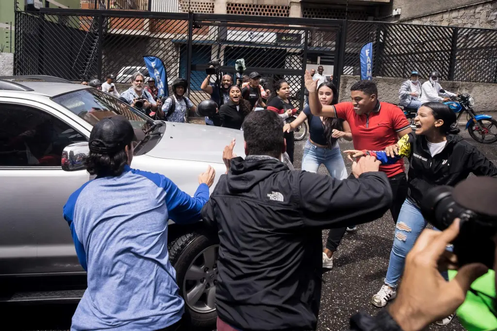 Fotografía donde se observa a un grupo de personas simpatizantes del oficialismo, rechazando un acto de campaña electoral para la elecciones primarias opositoras, en Caracas (Venezuela). EFE/ Miguel Gutierrez/