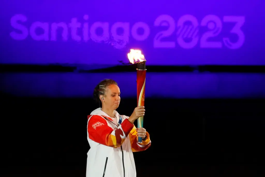 La nadadora chilena Kristel Köbrich porta la antorcha del fuego panamericano en la inauguración de los Juegos Panamericanos 2023 hoy, en el estadio Nacional en Santiago (Chile). EFE/Carlos Ortega
