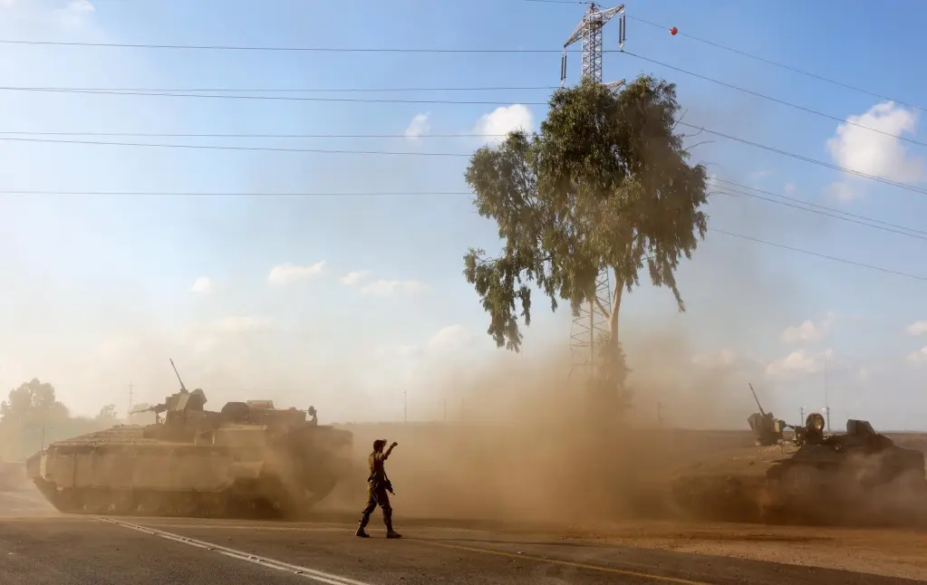 Vehículos blindados de transporte de tropas israelíes maniobran en una zona de la frontera con Gaza, al sur de Israel. EFE/ Abir Sultan