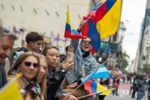 Una mujer ondea una bandera colombiana mientras observa el desfile del Día de la Hispanidad hoy, en la Quinta Avenida de Nueva York (EE.UU.). EFE/ Ángel Colmenares