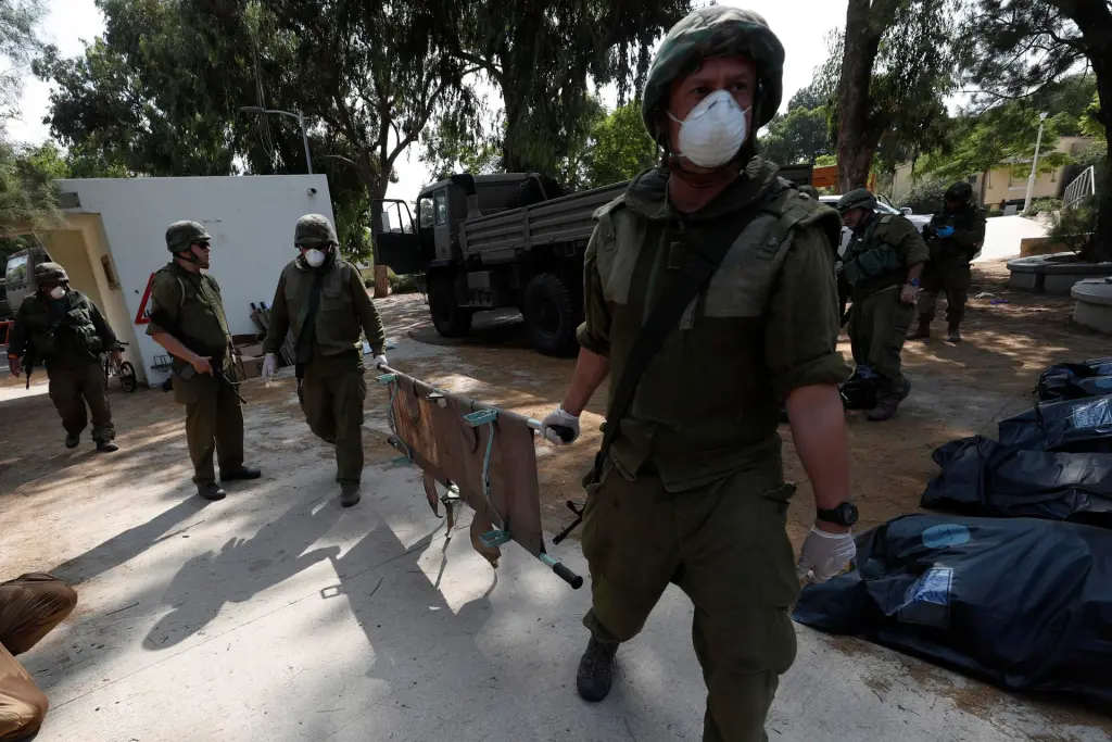 Soldados israelíes recogen los cuerpos de los israelíes asesinados en el kibutz de Kfar Aza, cerca de la frontera con Gaza. EFE/EPA/Atef Safadi