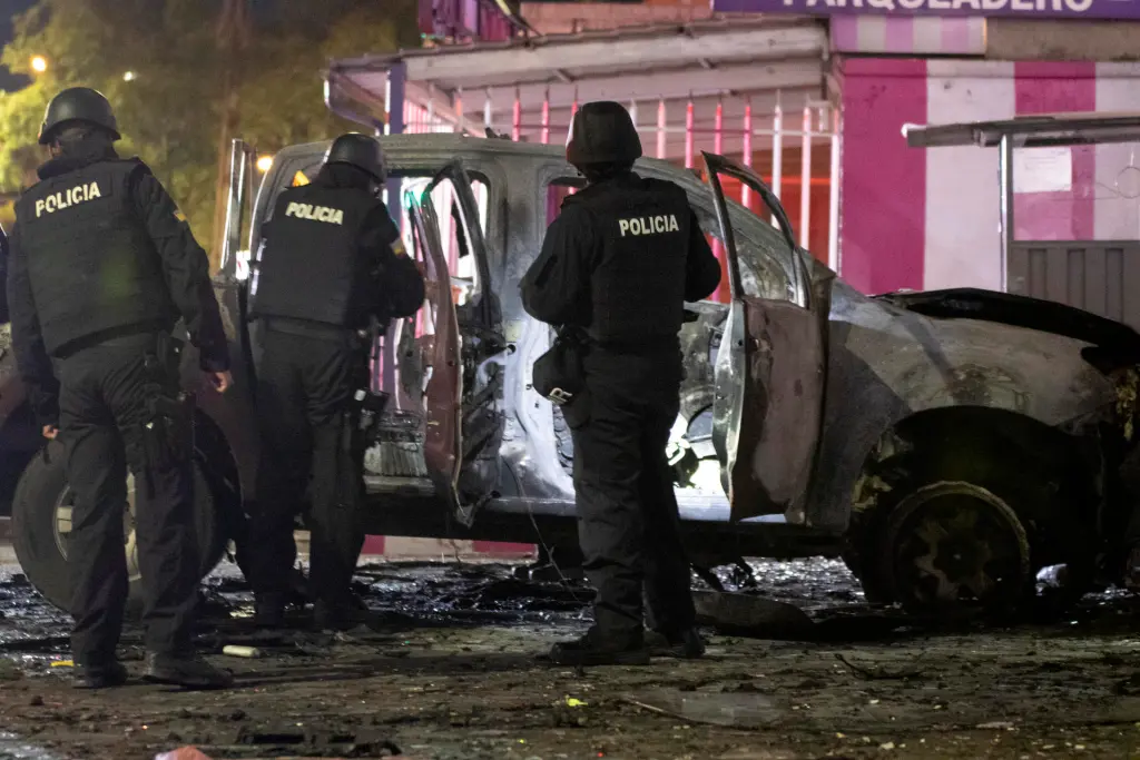Fotografía de archivo fechada el 31 de agosto de 2023 que muestra a un grupo de policías junto a los restos de un carro bomba que explotó en los exteriores del edificio del Servicio Nacional de Atención Integral a Personas Privadas de Libertad (SNAI), en Quito (Ecuador). EFE/ Str