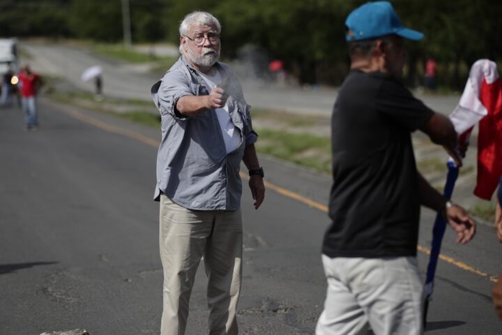 Un hombre dispara un arma hacia un manifestante en medio de un bloqueo de docentes en la vía Panamericana hoy, en Chame (Panamá). EFE/ Bienvenido Velasco