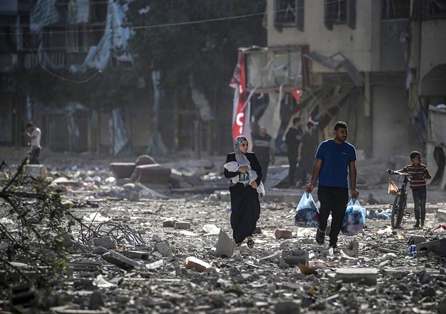 Foto de archivo de una familia palestina entre los escombros de los edificios alcanzados en un bombardeo israelí sobre la ciudad de Gaza. EFE/Mohammed Saber