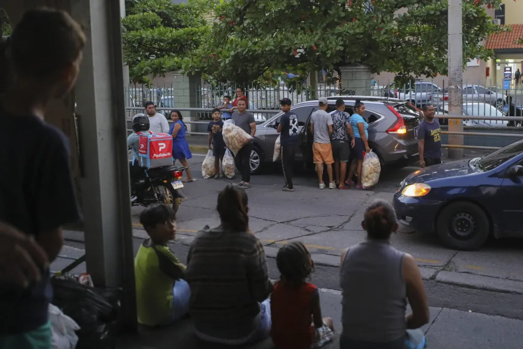 Migrantes permanecen en una estación de transporte público fuera de servicio en Tegucigalpa (Honduras). EFE/Gustavo Amador
