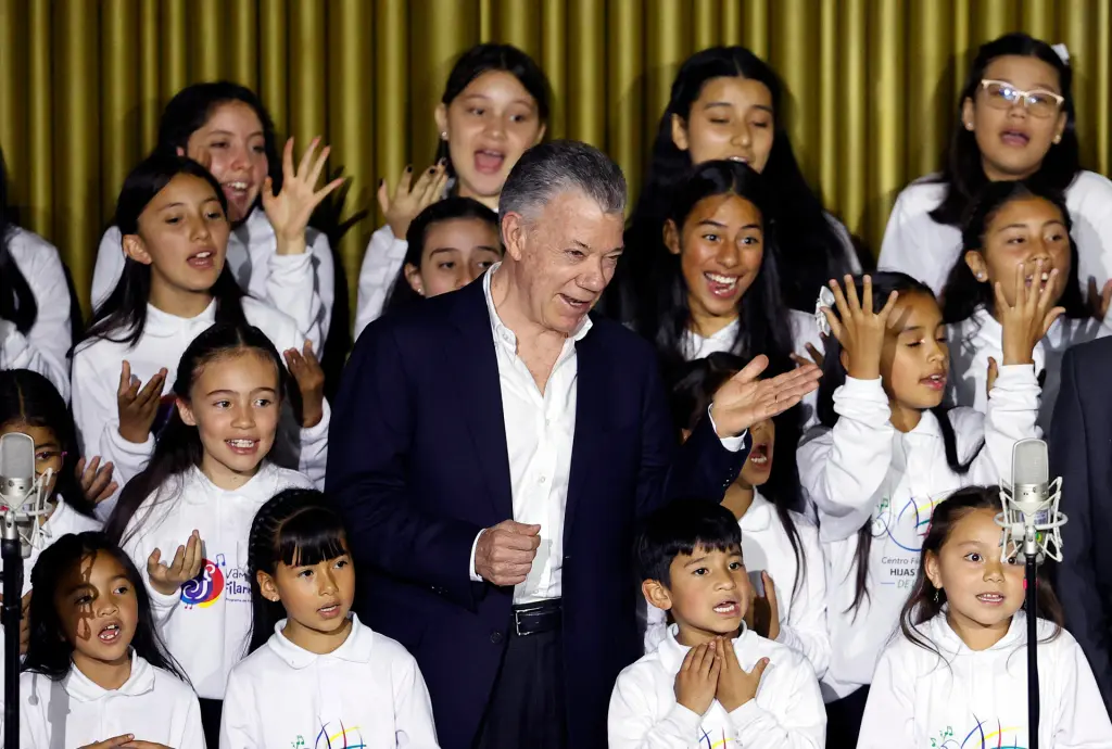 El expresidente de Colombia Juan Manuel Santos canta junto al "Coro de hijas e hijos por la paz", conformado por niños de los firmantes del acuerdo de paz, durante la conmemoración de los siete años de la firma de ese acuerdo entre Colombia y la guerrilla de las FARC, hoy, en el Centro Nacional de Memoria Histórica (CNMH) en Bogotá (Colombia). EFE/ Mauricio Dueñas Castañeda