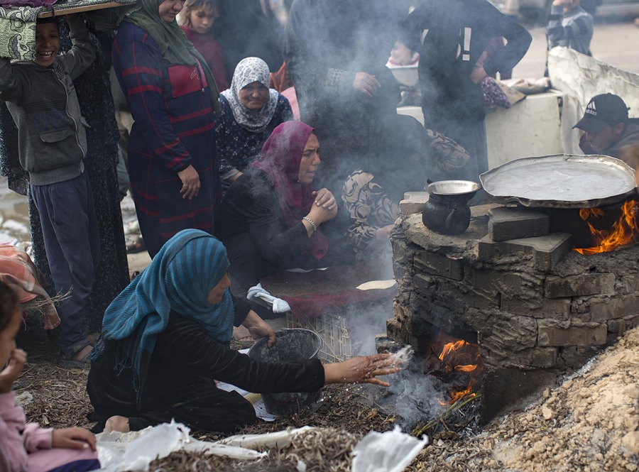 Familias palestinas desplazadas hacen pan en un horno de leña en un campo de refugiados en Rafah, en la Franja de Gaza. EFE/ Haitham Imad
