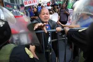 AME4606. LIMA (PERÚ), 15/12/2023.- Miembros del grupo ultraderechista peruano autodenominado La Resistencia agreden hoy al fotoperiodista Paolo Aguilar de la Agencia EFE, durante una manifestación frente al Congreso en Lima (Perú).