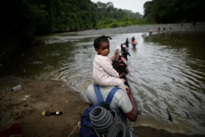 Migrantes cruzan el río Turquesa, en Darién (Panamá). EFE/Bienvenido Velasco