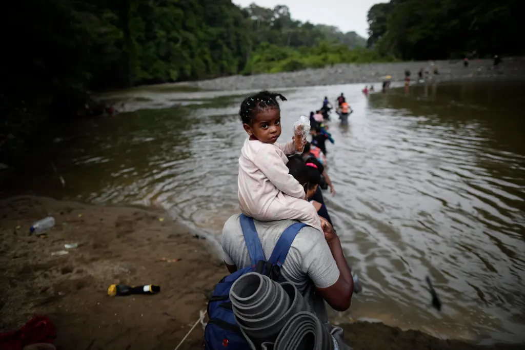 Migrantes cruzan el río Turquesa, en Darién (Panamá). EFE/Bienvenido Velasco