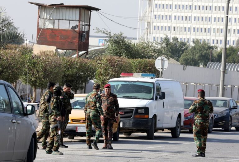 Las fuerzas de seguridad iraquíes se encuentran cerca de una puerta después de un ataque con drones contra un cuartel general de seguridad en Bagdad, Irak, el 4 de enero de 2024. EFE/EPA/AHMED JALIL