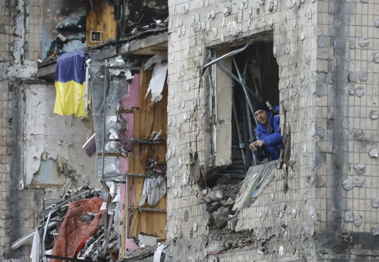 Un hombre mira por la ventana de su piso destruido de un edificio residencial dañado por los bombardeos rusos en Kiev (Ucrania). EFE/EPA/SERGEY DOLZHENKO