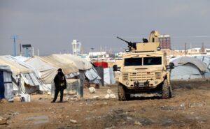 Un combatiente de las Fuerzas Democráticas de Siria (SDF) hace guardia durante una redada en un campamento de refugiados en en busca de personas sospechosas de pertenecer a células del Estado Islámico (EI). EFE/EPA/Ahmed Mardnli