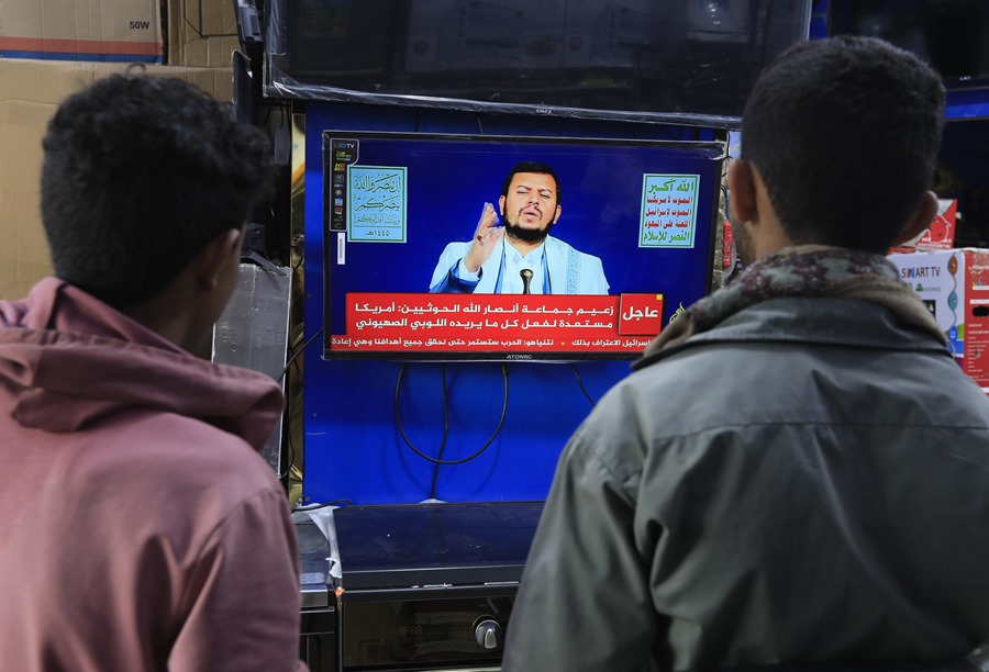 La gente observa al máximo líder hutí, Abdul-Malik al-Houthi, pronunciando un discurso televisivo. EFE/EPA/Yahya Arhab