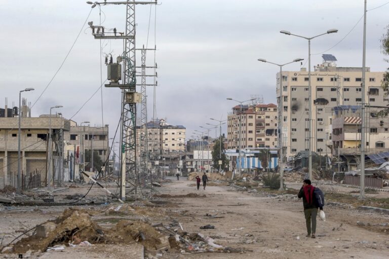 Palestinos caminan entre escombros a lo largo de la carretera Salah al-Din, en el sur de la Franja de Gaza. EFE/EPA/Mohammed Saber