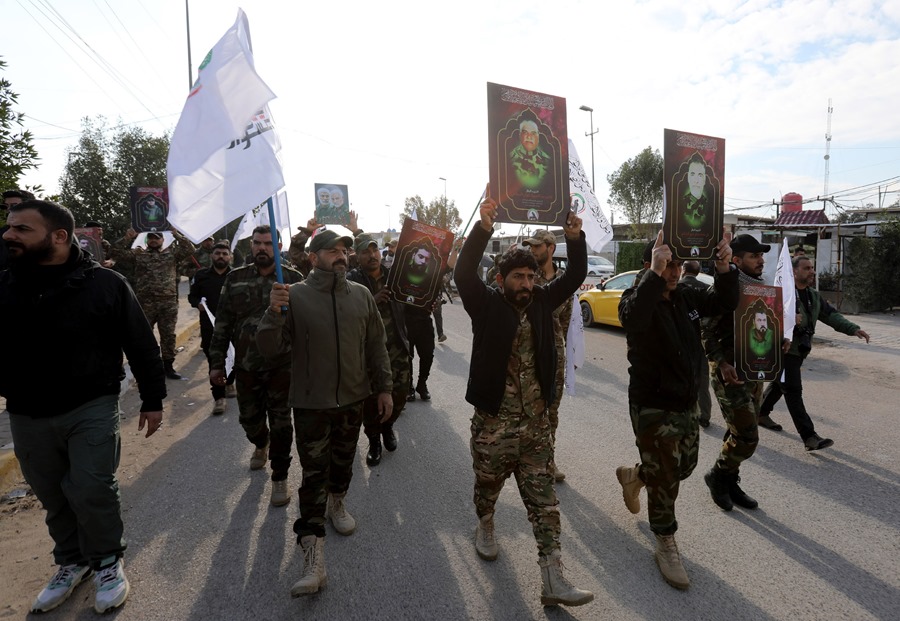 Miembros de las Fuerzas de Movilización Popular (FMP) chiítas iraquíes llevan imágenes de sus camaradas, que murieron en recientes ataques aéreos estadounidenses en el oeste de Irak,. EFE/EPA/Ahmed Jalil
