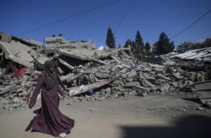 Una mujer palestina pasa junto a escombros tras un ataque de Israel en Al Maghazi, al sur de Gaza. EFE/EPA/Mohammed Saber