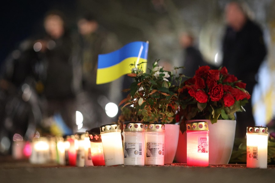 Velas junto a flores y una bandera ucraniana durante una manifestación contra la guerra en Ucrania. EFE/EPA/Clemens Bilan