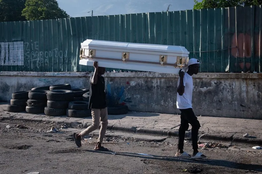 Dos hombres portan un ataud en una calle de Puerto Príncipe el pasado 9 de marzo. EFE/ Johnson Sabin