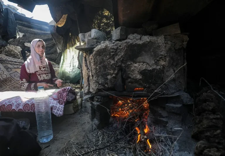 Una mujer palestina desplazada internamente hornea pan en un horno en Deir Al Balah, al sur de la Franja. EFE/EPA/Mohammed Saber