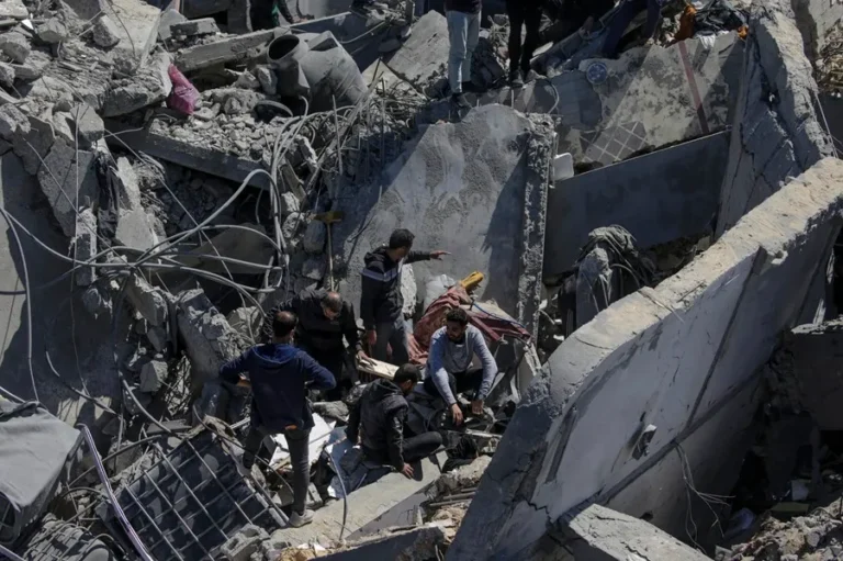 Palestinos buscan personas desaparecidas bajo los escombros de una casa destruida en el campo de refugiados de Al Nusairat. EFE/EPA/Mohammed Saber