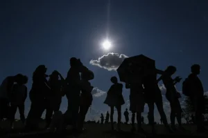 Imagen de archivo de personas observan un eclipse solar parcial. EFE/Andre Borges
