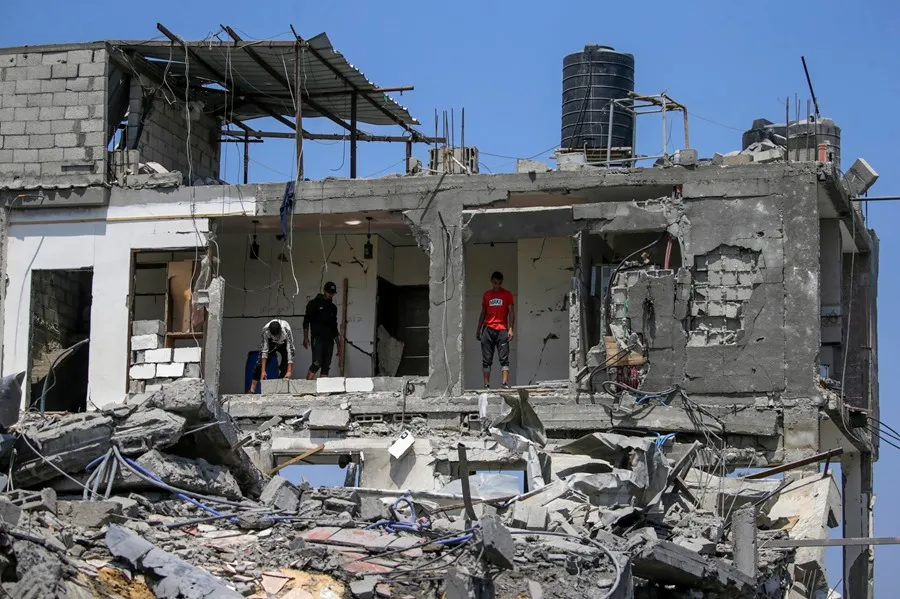 Palestinos inspeccionan sus casas destruidas en el campo de refugiados de Al Maghazi, centro de la Franja de Gaza. EFE/Mohammed Saber