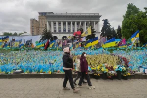 Una mujer y dos niñas pasan por delante de unas banderas que recuerdan a los soldados ucranianos caídos desde el comienzo de la invasión rusa de Ucrania en el centro de Kiev. EFE/ Marcel Gascón