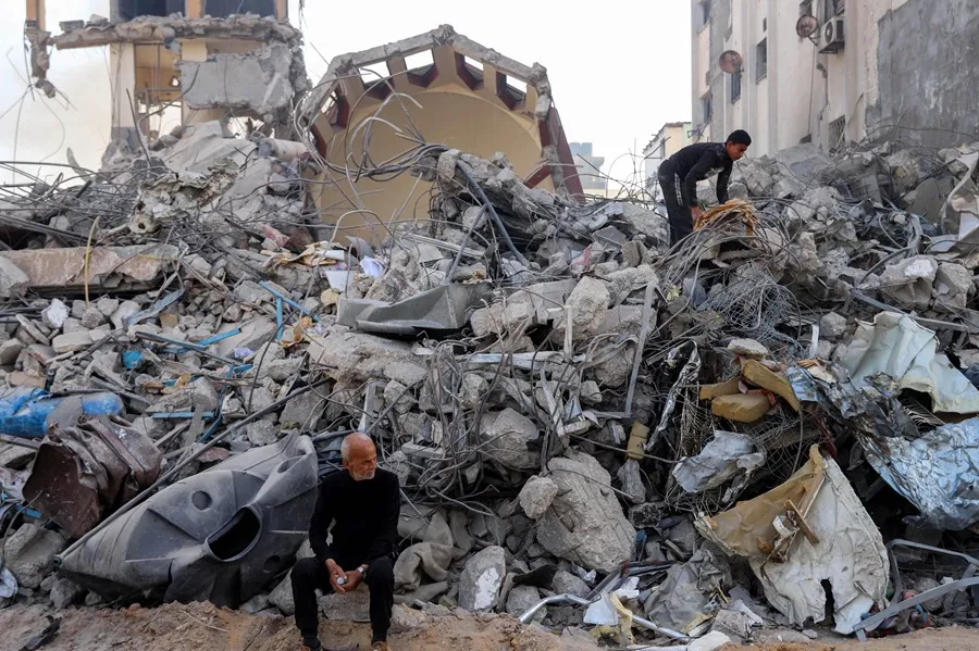 Dos palestinos inspeccionan los escombros cerca del Hospital Al-Shifa, después de que el Ejército israelí se retirara del mismo tras una operación militar de dos semanas en la ciudad de Gaza, en una imagen del 1 de abril de 2024. EFE/MOHAMED HAJJAR