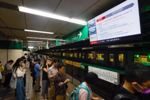 Pasajeros esperan debajo de una pantalla que transmite un anuncio de suspensión del metro luego de un terremoto cerca de Hualien, en Taipéi (Taiwán). EFE/EPA/Daniel Ceng
