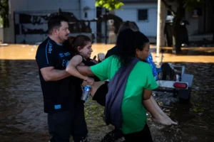 Pobladores del barrio Farrapos reciben ayuda para evacuar sus viviendas tras la crecida del lago Guaíba este lunes en Porto Alegre (Brasil). El nivel del río Guaíba, cuyas aguas inundaron el centro histórico de Porto Alegre, la capital regional y donde viven 1,3 millones de habitantes, se estabilizó por encima de los cinco metros, su mayor marca histórica. EFE/ Isaac Fontana