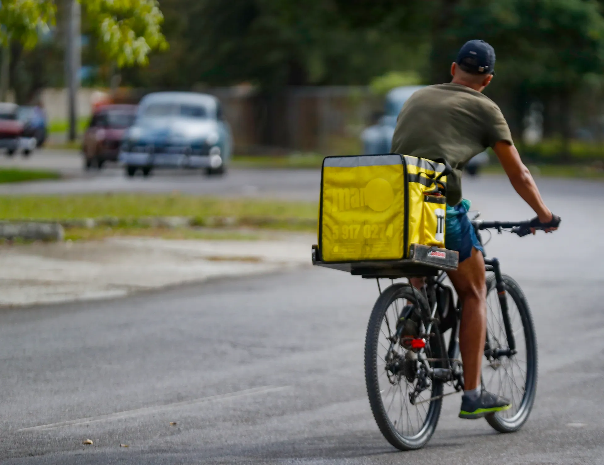 Un mensajero de la empresa privada Mandao (de entrega de comida a domicilio) transita en bicicleta, el 9 de junio de 2024, por una de las calles de La Habana (Cuba). EFE/Yander Zamora
